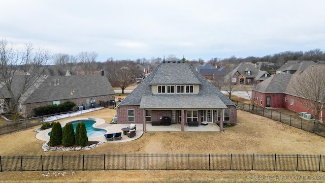 back of property featuring a fenced in pool and a patio