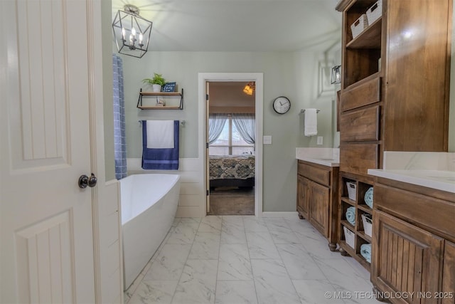 bathroom featuring a washtub, vanity, and a chandelier