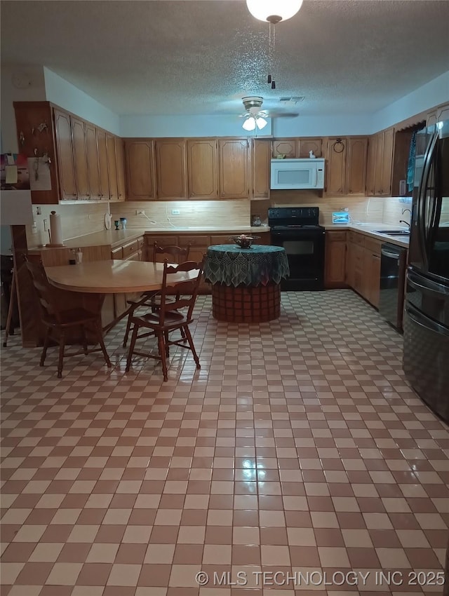 kitchen featuring a textured ceiling, ceiling fan, sink, and black appliances