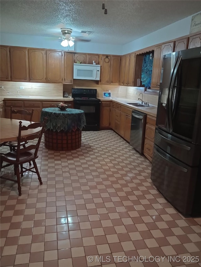 kitchen with sink, a textured ceiling, and black appliances