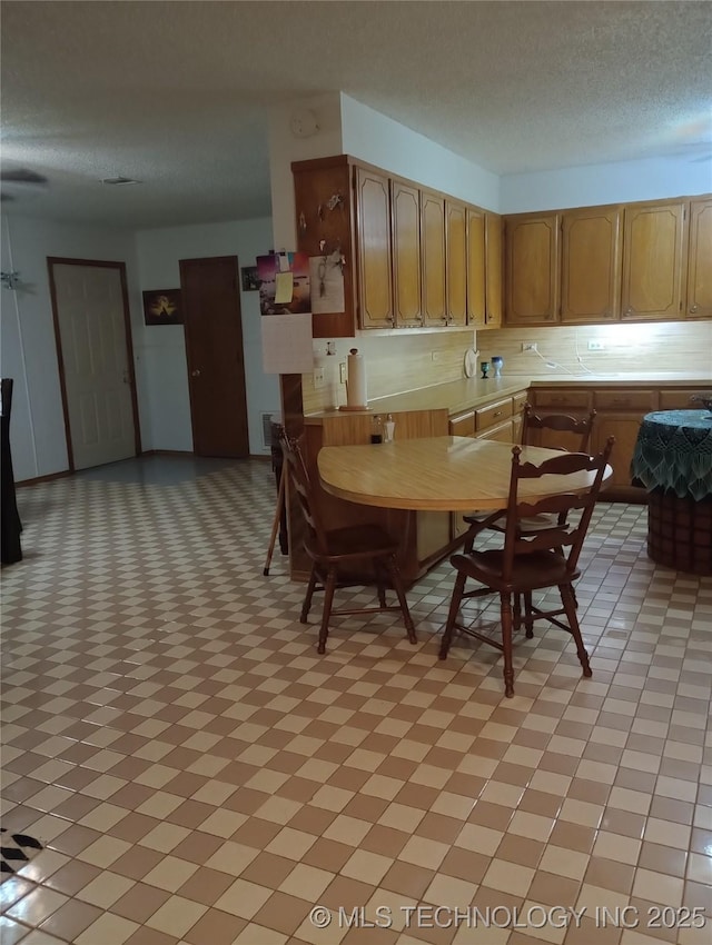 unfurnished dining area featuring a textured ceiling