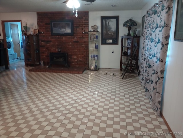 unfurnished living room featuring ceiling fan and a wood stove