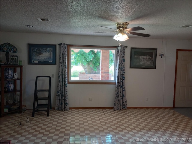 unfurnished room featuring ceiling fan and a textured ceiling