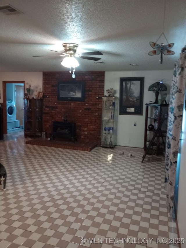 unfurnished living room featuring a textured ceiling and washer / dryer