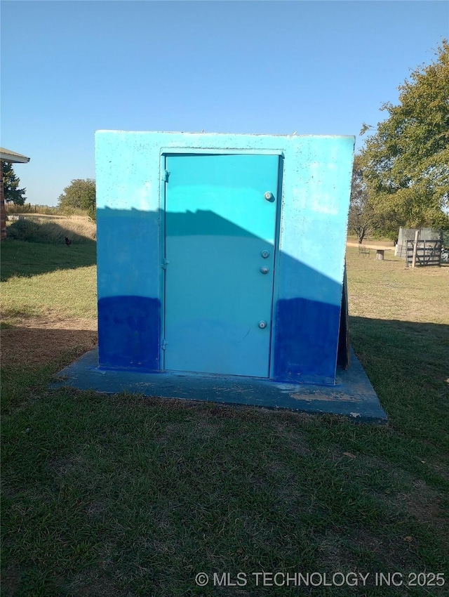 view of storm shelter featuring a lawn