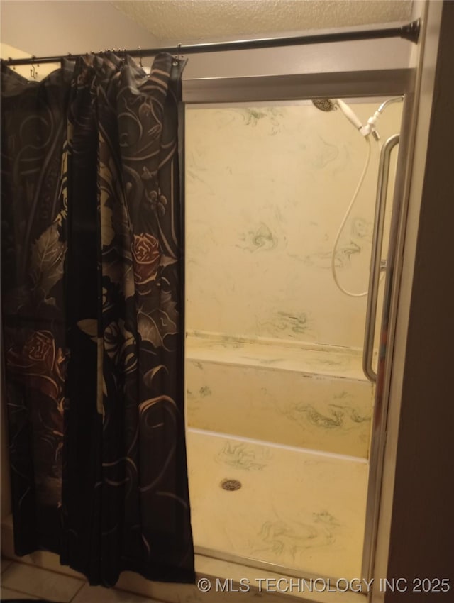 bathroom with walk in shower and a textured ceiling