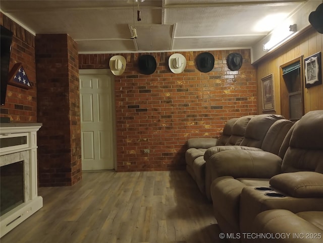 living room featuring brick wall, a premium fireplace, hardwood / wood-style floors, and wooden walls