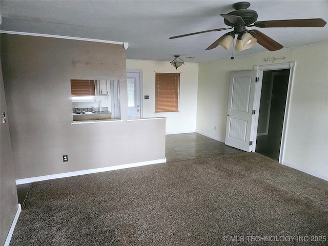 unfurnished room with ceiling fan and dark carpet