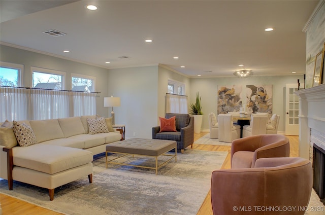 living room with crown molding and light hardwood / wood-style floors