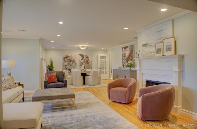 living room featuring crown molding and light hardwood / wood-style floors