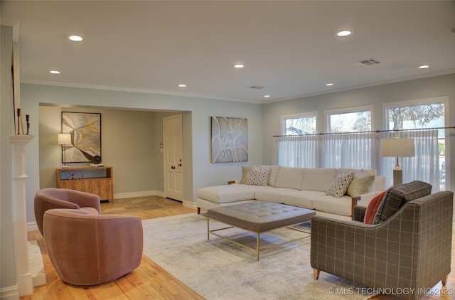 living room with crown molding and light wood-type flooring