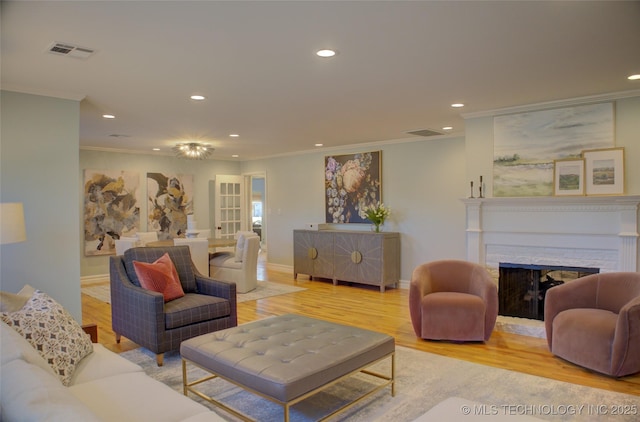 living room with ornamental molding and light hardwood / wood-style floors