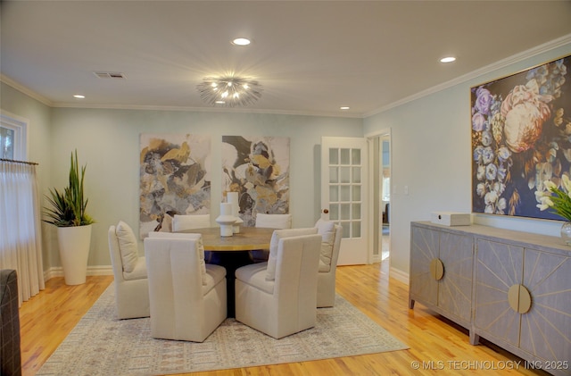 dining room featuring ornamental molding and light wood-type flooring