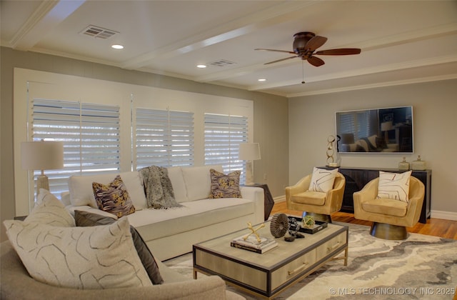 living room featuring ceiling fan, ornamental molding, beam ceiling, and light hardwood / wood-style flooring