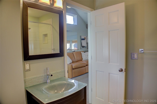 bathroom with backsplash, walk in shower, vanity, and lofted ceiling