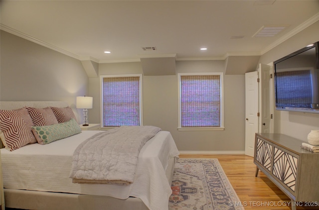 bedroom featuring ornamental molding and light wood-type flooring