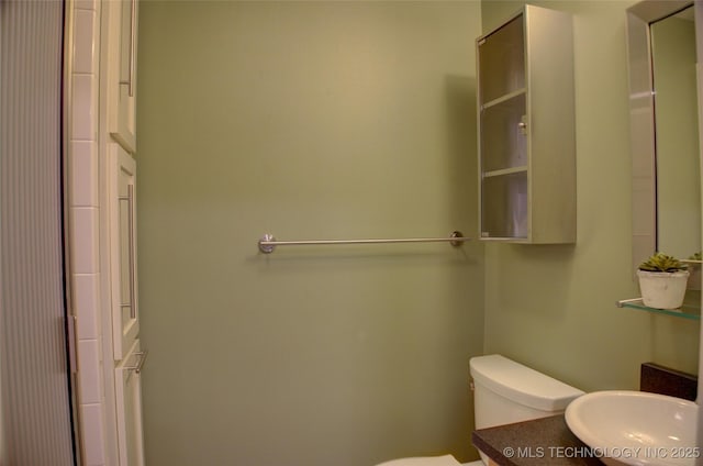 bathroom featuring toilet, vanity, and an enclosed shower