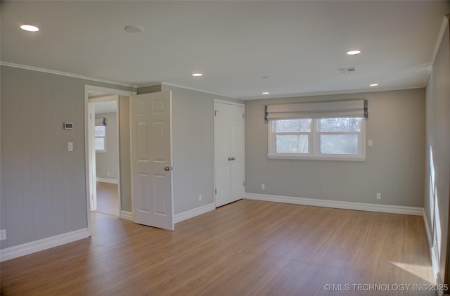 interior space featuring a wealth of natural light, ornamental molding, and light hardwood / wood-style flooring