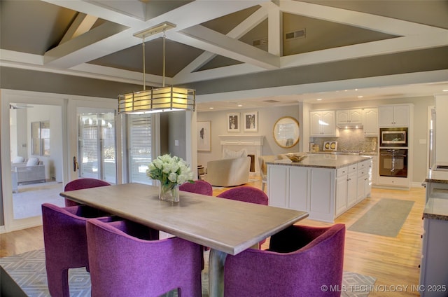 dining space featuring light hardwood / wood-style floors and high vaulted ceiling