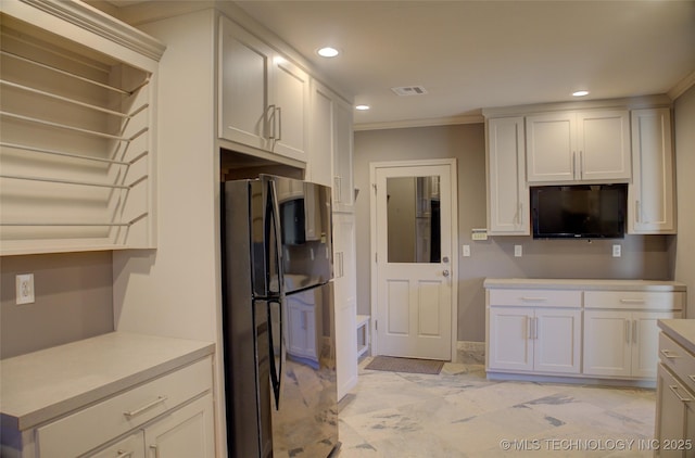 kitchen featuring crown molding, white cabinets, and black refrigerator