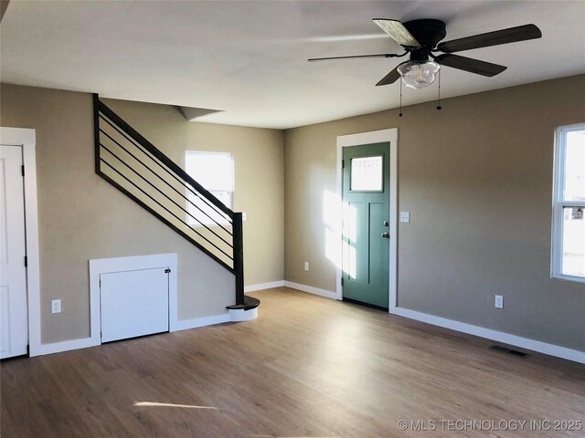 foyer entrance with ceiling fan and light wood-type flooring