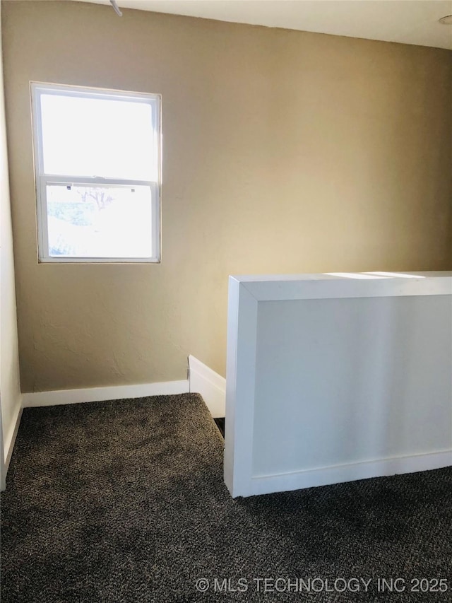 empty room featuring dark colored carpet