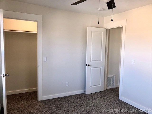 unfurnished bedroom with ceiling fan, baseboards, visible vents, and dark carpet