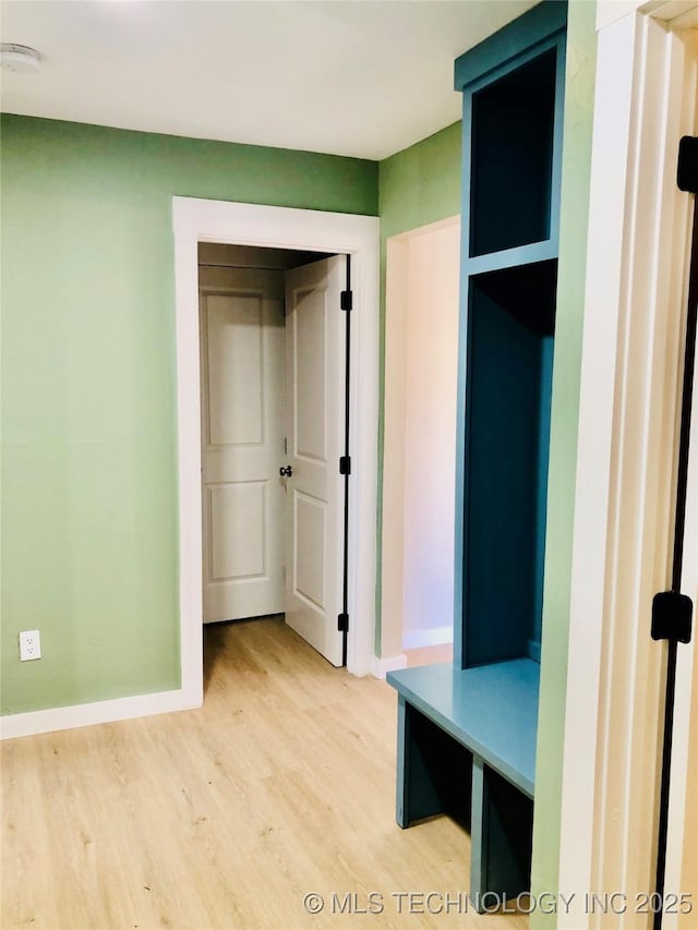 mudroom featuring light wood finished floors and baseboards