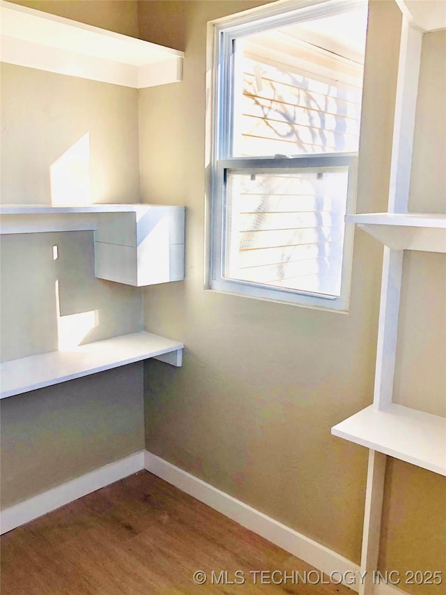 interior space with wood finished floors and baseboards