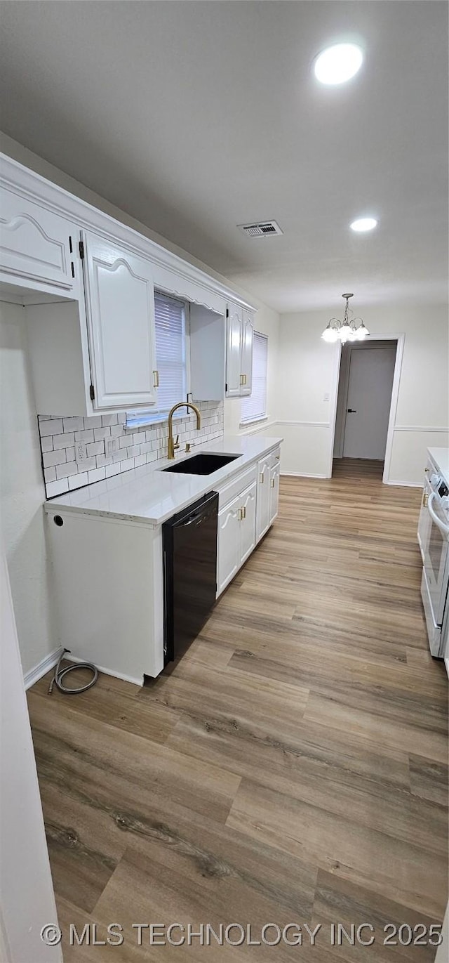 kitchen featuring light hardwood / wood-style flooring, sink, black dishwasher, and white cabinetry