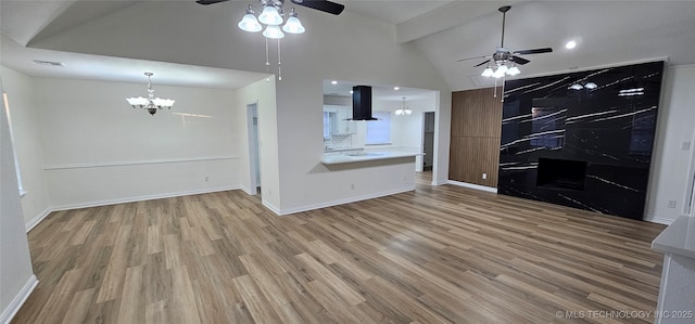 unfurnished living room featuring high vaulted ceiling, wood-type flooring, beam ceiling, and ceiling fan with notable chandelier