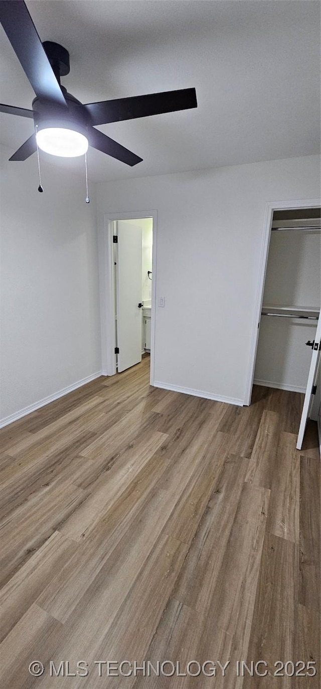 unfurnished bedroom featuring ceiling fan, light hardwood / wood-style floors, and a closet