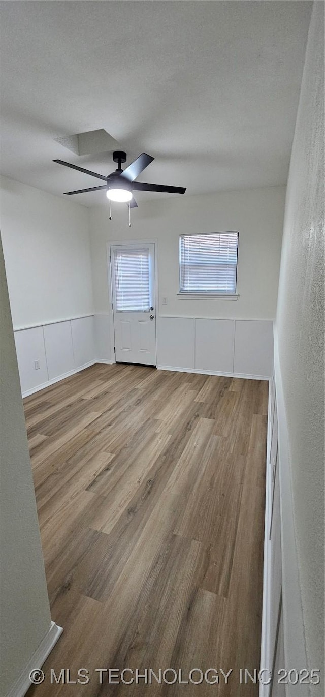 unfurnished room with ceiling fan, a textured ceiling, and hardwood / wood-style floors