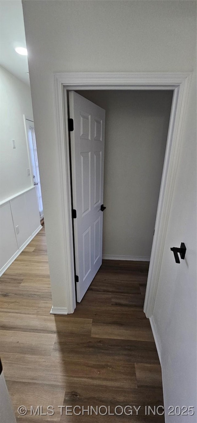 hallway with hardwood / wood-style flooring