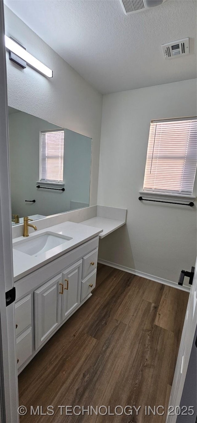 bathroom with vanity, a textured ceiling, and hardwood / wood-style floors