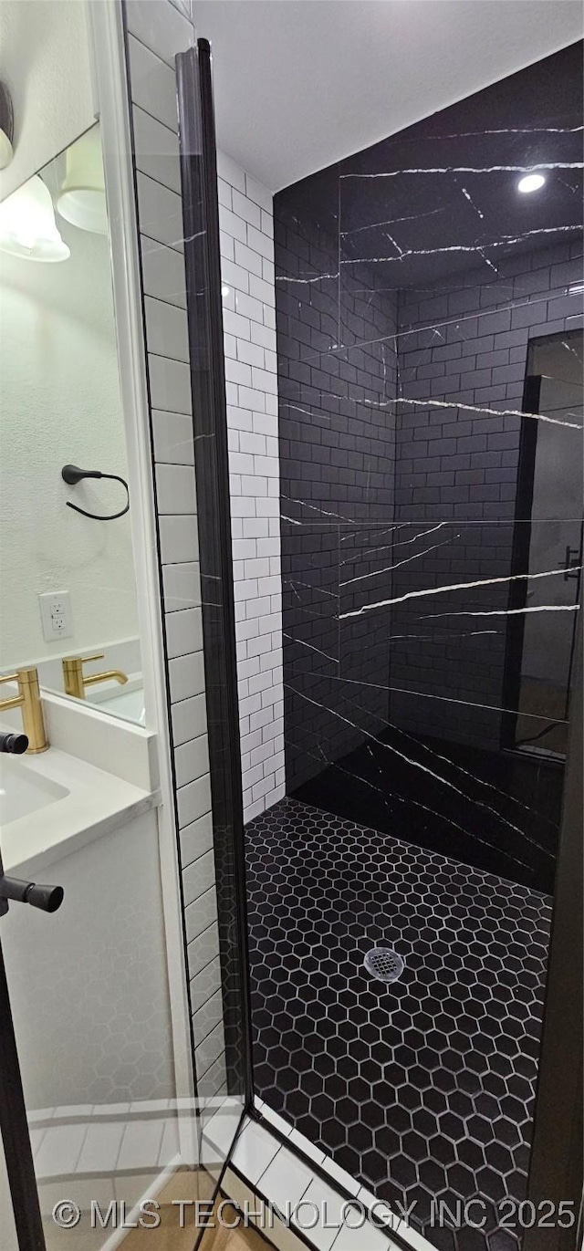 bathroom with sink and a tile shower