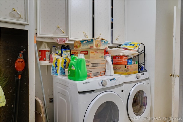 laundry area featuring washing machine and clothes dryer and cabinets