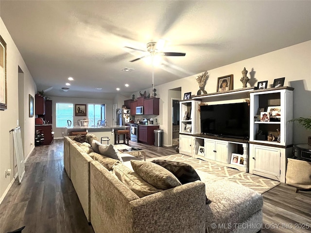 living room featuring ceiling fan and dark hardwood / wood-style floors