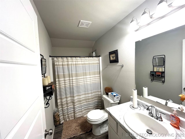 bathroom featuring toilet, vaulted ceiling, walk in shower, and vanity