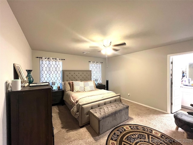 bedroom featuring ceiling fan, light colored carpet, and ensuite bathroom