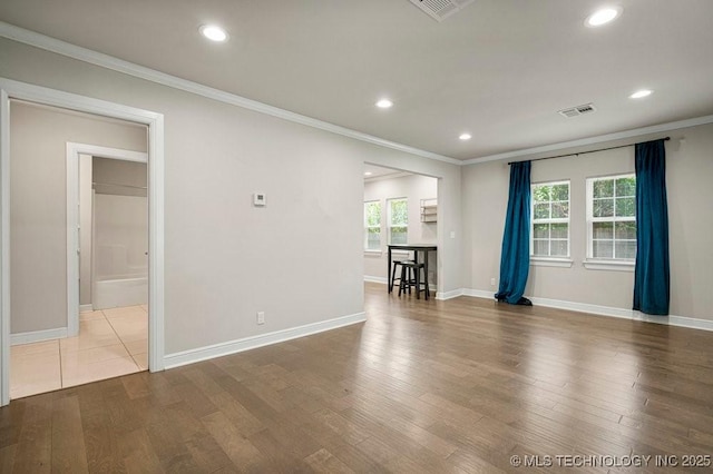 empty room featuring crown molding and wood-type flooring