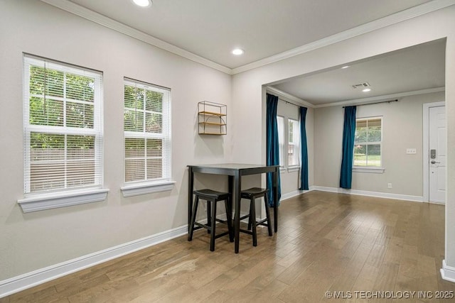 dining space featuring ornamental molding and hardwood / wood-style floors