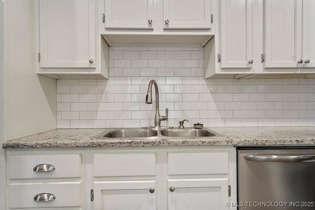 kitchen featuring white cabinets, stainless steel dishwasher, and tasteful backsplash