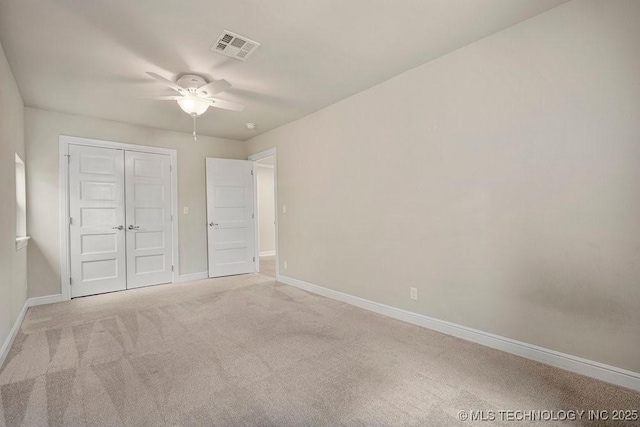 unfurnished bedroom featuring light carpet, ceiling fan, and a closet