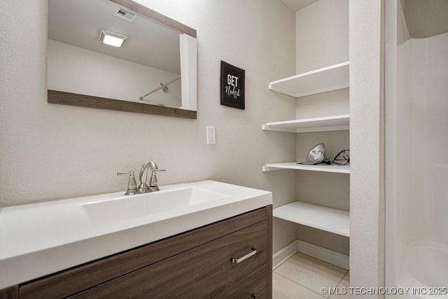 bathroom featuring vanity, tile patterned flooring, and a shower