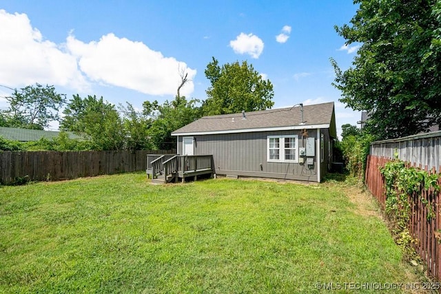 rear view of house featuring a deck and a yard