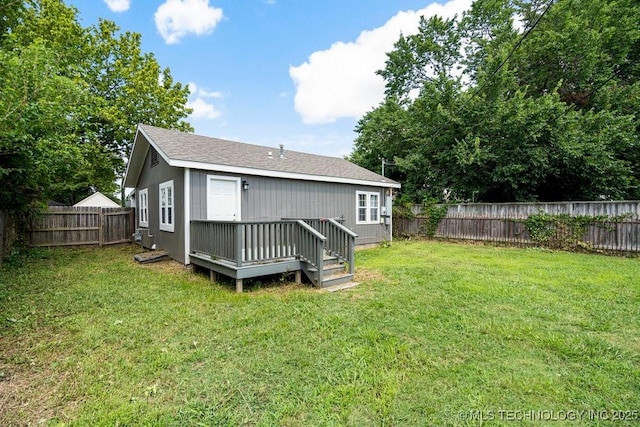 back of house with a wooden deck and a lawn