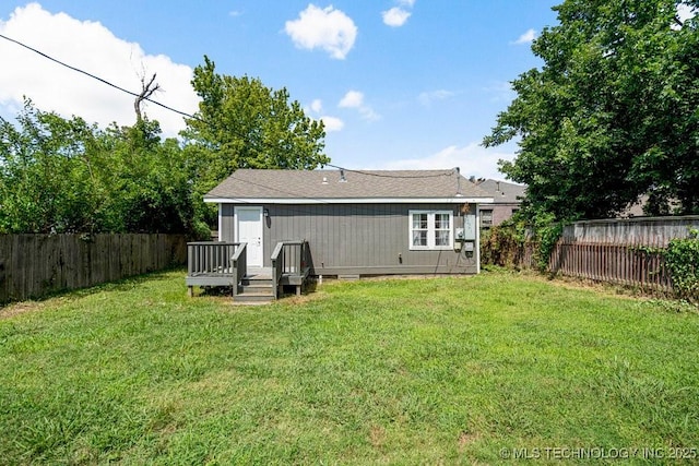 back of property with a lawn and a wooden deck