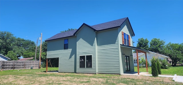 rear view of property featuring a lawn