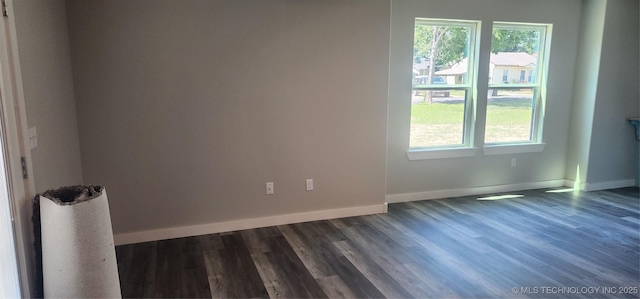 unfurnished room with dark wood-type flooring and plenty of natural light